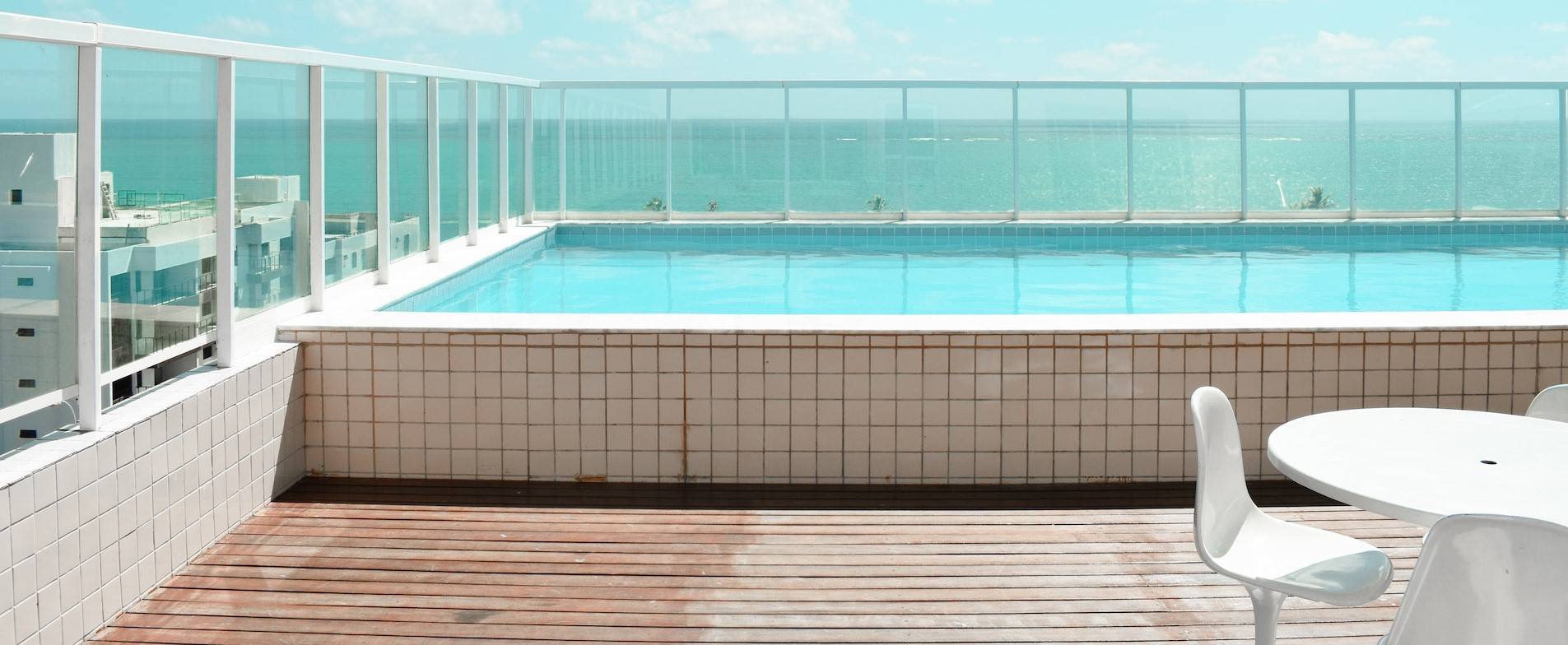 Une piscine est sur une terrasse ensoleillée.