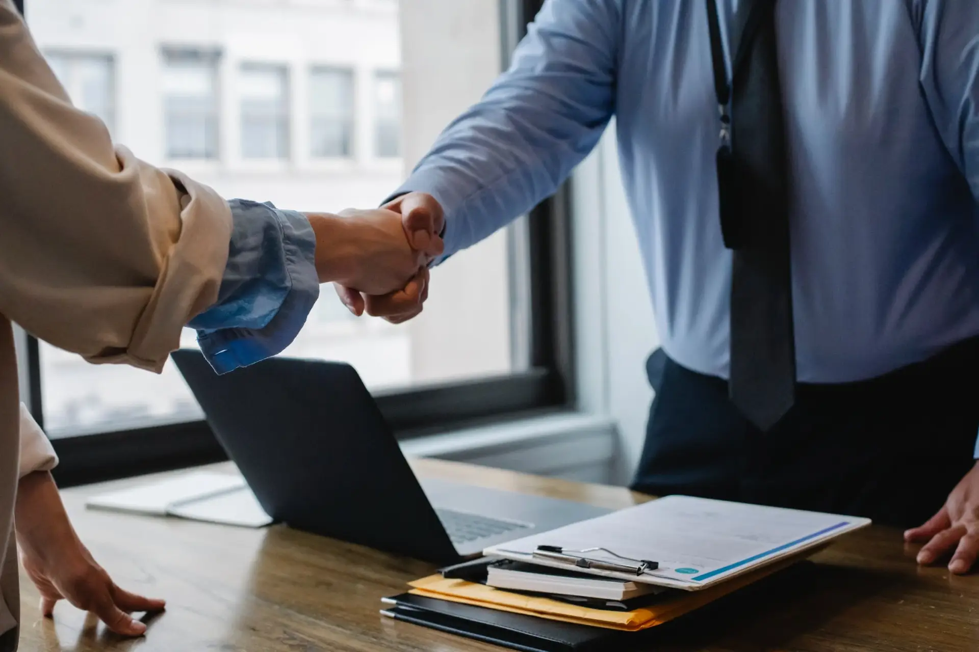 deux hommes se serrent la main autour d'un contrat.