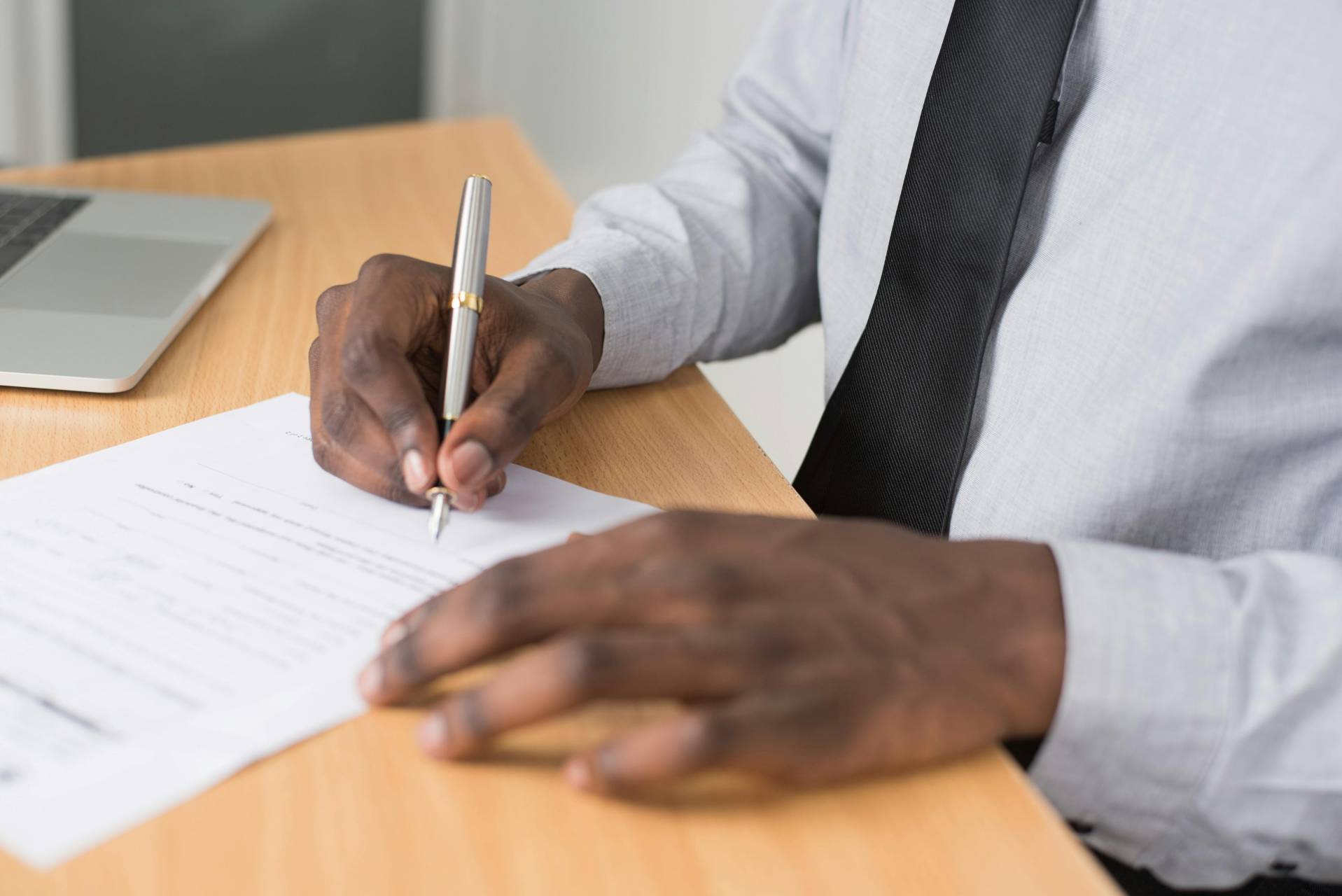 Homme écrivant sur une feuille de papier